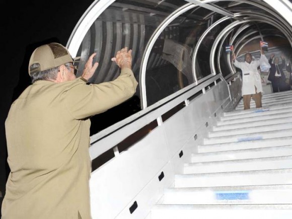 Raul Castro waves goodbye to a Cuban healthcare worker leaving for an overseas post