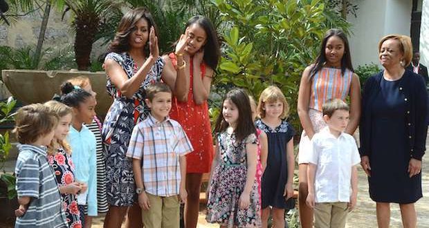 Michelle Obama, her mother, Marian Robinson, and her daughters, Malia and Sasha, pose together with a group of Cuban children after having planted two magnolia bushes, similar to the ones that bloom in the White House gardens, and after donating a wooden bench for the relaxation of visitors to the Rubén Martínez Villena library garden in Old Havana. Taken from Impacto New York. 