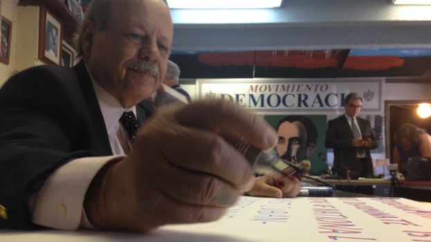 A Democracy Movement activist prepares posters for the protest against American Airlines. (14ymedio)